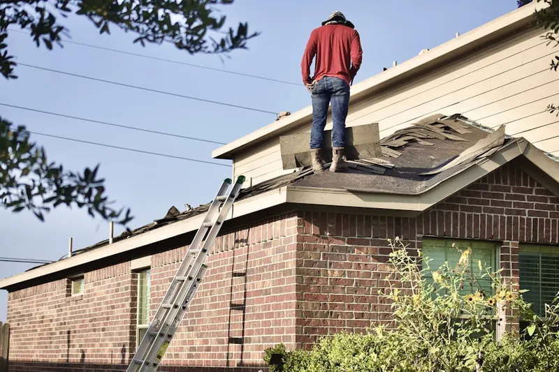 Professional roofer working on a residential roof in Meyerland Area